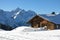 Facade of a old timber hut and snow covered mount Oldenhorn. Win