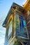 Facade of an old wooden house with stained-glass windows in outbuilding against the sky in perspective, fragment, blurred image