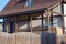 Facade of a private house with an open wooden veranda under a brown tiled roof with a window