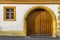 Facade of a restored half-timbered house partly plastered with window and driveway with round arch and fitted wooden gate