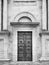 Facade of a romanesque italian church with wooden carved portal