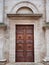 Facade of a romanesque italian church with wooden carved portal