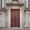 Facade of a romanesque italian church with wooden carved portal