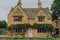 Facade of a traditional detached limestone house in Broadway, Cotswolds, UK