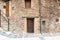 Facade of a traditional house built with slates, clay and with an old beautiful wooden door