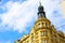 Facade of typical colorful classic building with a rounded tower in a street in the old town of Prague, Czech Republic