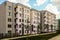 Facade typical middle storey residential building under a blue cloudy sky and footpath slope