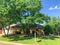 Facade of typical suburban corner house with for sale sign post stake near Dallas, Texas, America