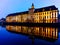 Facade of University of Wroclaw building reflecting in Odra river at afternoon with christmas