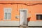 A facade of a vibrant orange house with a window and an open white front door in Galdar, Gran Canaria