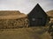 Facade of a wooden house surrounded by peat