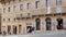 Facades of historic buildings in the center of Siena with shops and tourists