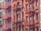 Facades of historic buildings in the Soho district of New York. The characteristic iron safety stairs on the facades