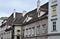 Facades of historic buildings in Vienna, with tiled roofs arranged like fish scales, under the blue sky.