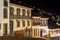 Facades of houses in colonial architecture on an old cobblestone street at night