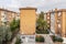 Facades of urban residential homes with gardens with hedges, varied trees and palm trees in common areas