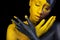 Face art. Woman with black and yellow body paint. Young african girl with colorful bodypaint. An amazing model with