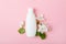 Face care products tonic or lotion, serum, spray, micellar water on pink background with spring apple blossom.