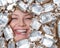 The face of a Caucasian woman surrounded by candy wrappers. girl showing tongue.