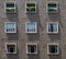 Face of cement apartment building with 9 symmetrical windows in Bologna Italy