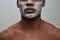 Face closeup of shirtless young african american man using facial blackhead removal mask, posing isolated over gray