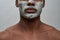 Face closeup of shirtless young african american man using facial blackhead removal mask, posing isolated over gray