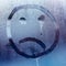 The face of the coronavirus. Image on wet glass of a crying man. Mood during quarantine