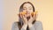 Face of cute girl grimacing with halfs of orange fruit in hands, teenager having fun and positive mood on studio background, conce