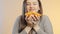 Face of cute girl grimacing with halfs of orange fruit in hands, teenager having fun and positive mood on studio background, conce