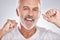 Face, dental floss and senior man in studio isolated on a gray background. Portrait, cleaning and elderly male model