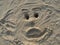 Face drawn in sand