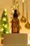 Face essential oil with natural ingredients on podium on festive new year background with cristmas tre and baubles. New year or