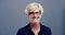 Face, excited woman and wink in glasses in studio isolated on a grey background mockup with gesture on backdrop