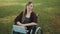 Face expression of young caucasian disabled woman in the wheelchair with laptop in the park