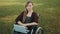 Face expression of young caucasian disabled woman in the wheelchair with laptop in the park