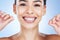 Face, flossing teeth and dental with woman, hygiene and beauty with grooming and mouth care on blue background. Hands