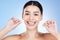 Face, flossing teeth and hygiene with woman, dental and beauty with grooming and mouth care on blue background. Hands