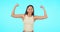 Face, funny and woman flex muscle in studio isolated on a blue background mockup. Portrait, strong arms and happy female