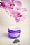 Face/hand cream jar and purple orchid flowers, vertical shot