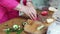 without a face. hands slice tomatoes for vegetable salad on a cutting board.