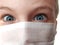 Face of a handsome white old boy in a white protective surgical mask. Eyes with a gray iris. Surprised look and emotion. Blonde