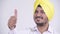 Face of happy bearded Indian Sikh businessman giving thumbs up