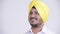 Face of happy bearded Indian Sikh businessman with turban thinking