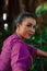 The face of a Javanese woman with makeup and a traditional purple dress called kebaya while dancing and posing with jewelry on her