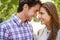 Face, love and couple in park with forehead, touch and bonding against a blurred background. Happy, embrace and man with