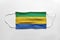 Face mask with Gabon flag printed, on white background, isolated