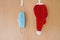 Face mask and santa claus hat hanging side by side on door hooks - christmas during covid-19 corona pandemic