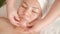 Face massage of a middle-aged Asian woman in a beauty salon. Close-up. The movement of the fingers of the beautician`s hands from