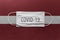 Face Medical Surgical White Mask with COVID-19 inscription lying on Latvia National Flag. Coronavirus in Latvia