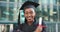 Face, outdoor and black woman with graduation, degree or celebration with cap, certificate or university. Portrait